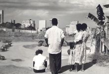 Família assiste às obras do morro, de cima de uma ribanceira